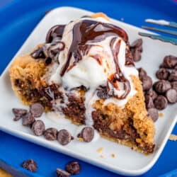 A photo of chocolate chip cookie pie on a blue plate.