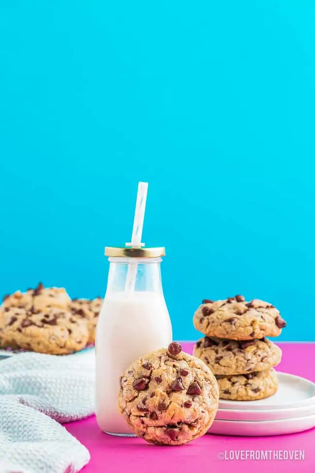a stack of chocolate chip cookies and bottle of milk