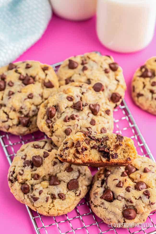 Photos of levain chocolate chip cookies on a pink background