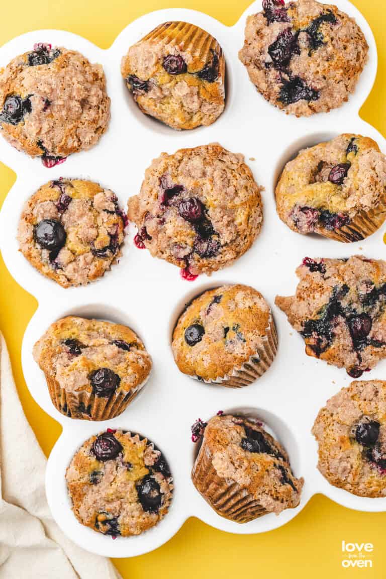 A white muffin pan holding blueberry banana muffins