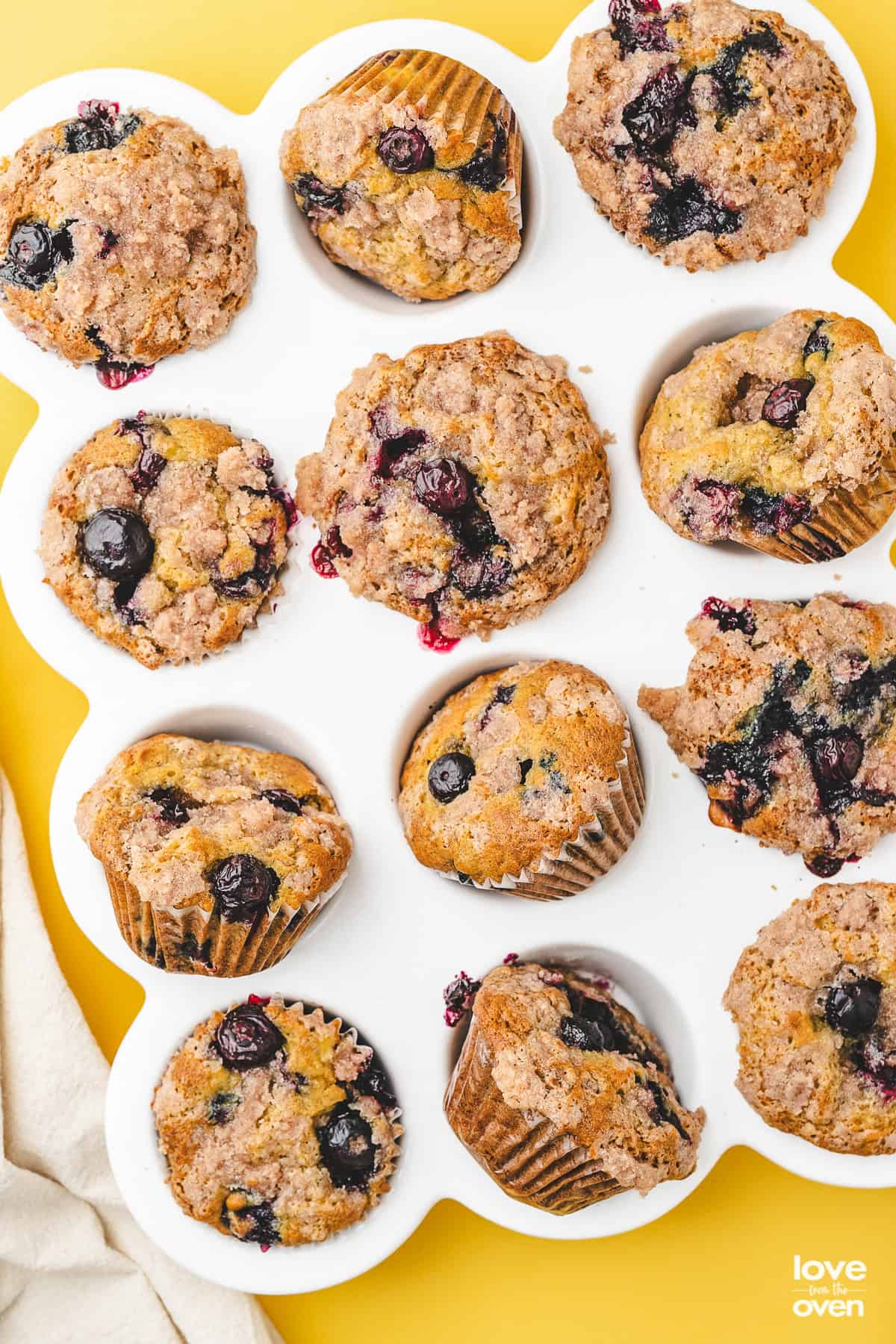 A white muffin pan holding blueberry banana muffins