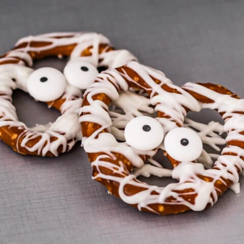two halloween chocolate covered pretzels that look like mummies