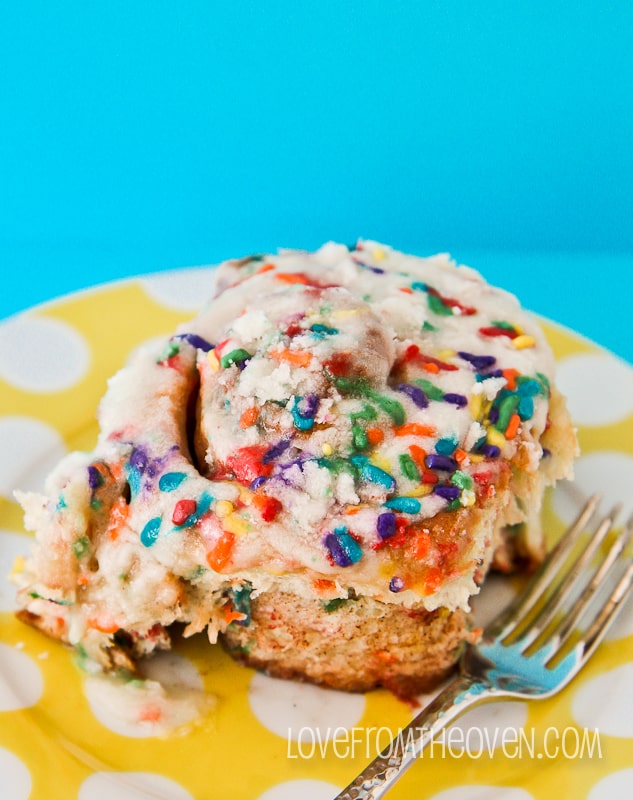 A cinnamon roll with sprinkles on top.