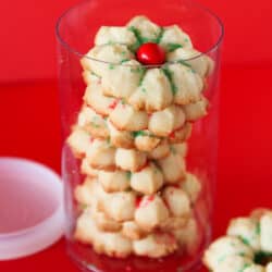 A container of spritz cookies on a red background