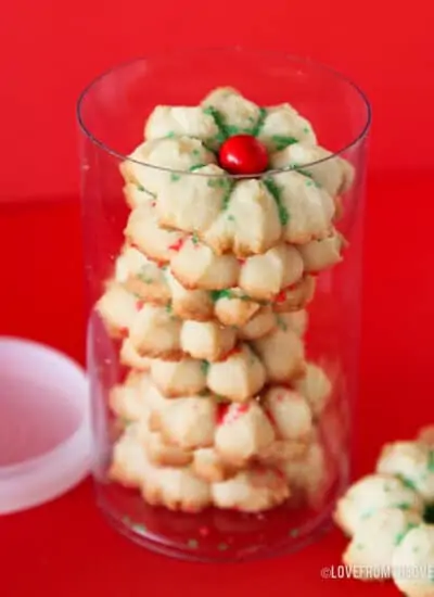 A container of spritz cookies on a red background