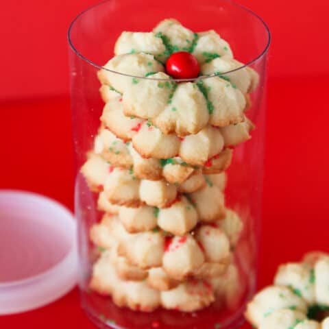 A container of spritz cookies on a red background