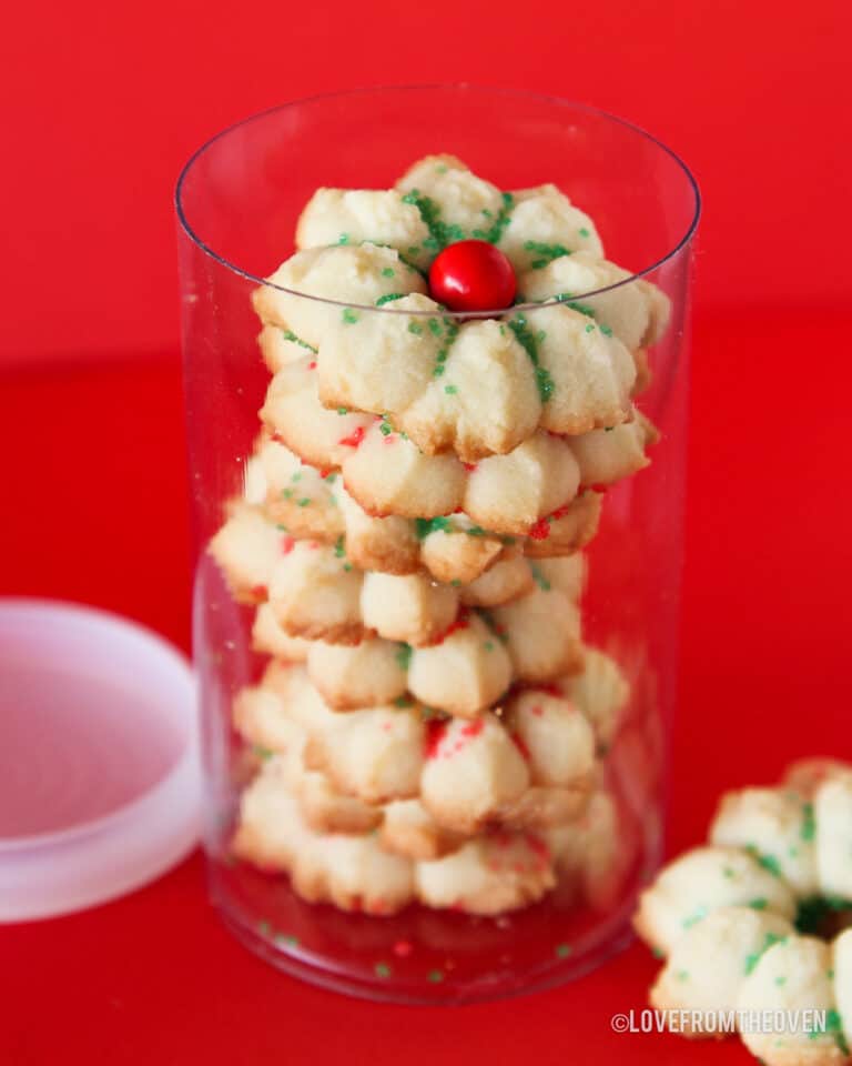 A container of spritz cookies on a red background