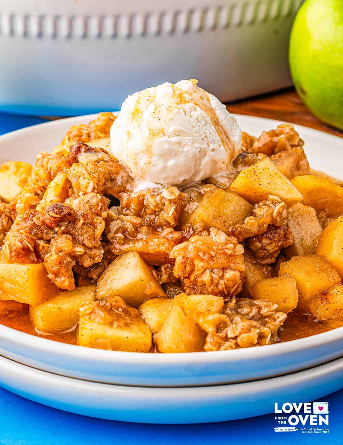 a plate of apple crumble with a scoop of ice cream on top