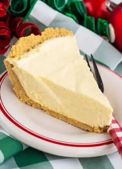 A slice of eggnog pie on a white plate with green and white napkins