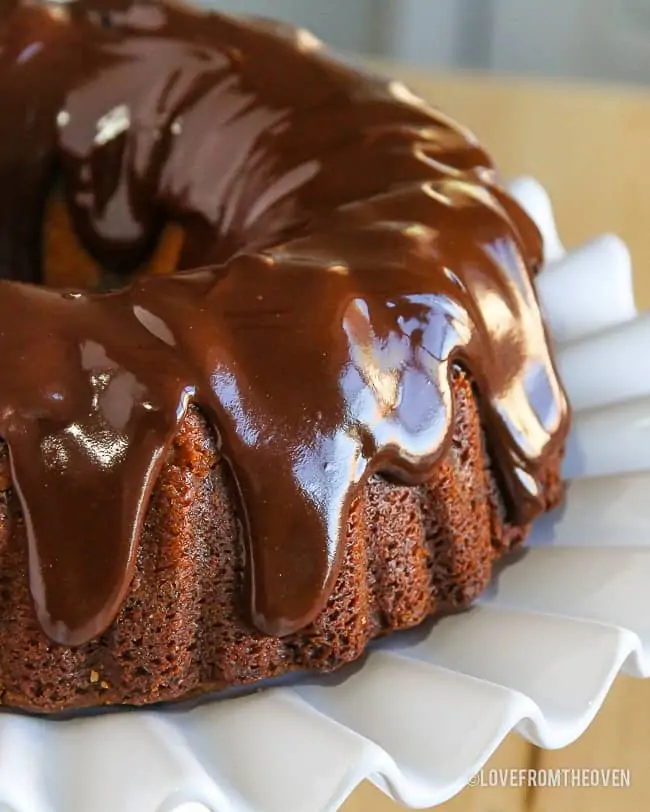 A chocolate chip bundt cake on white cake stand