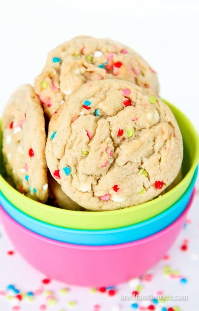 Three funfetti cookies in a multicolored bowl