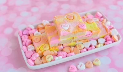 Stack of sugar cookie bars on a tray filled with candy hearts