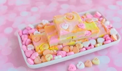 Stack of sugar cookie bars on a tray filled with candy hearts