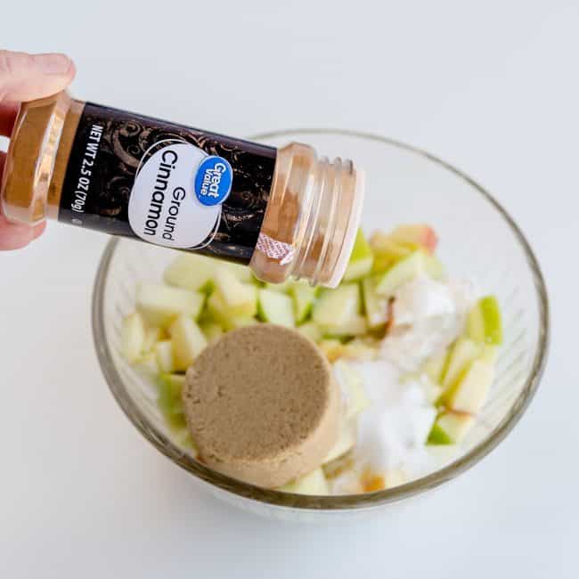 Diced apples with sugar, brown sugar and cinnamon in a bowl