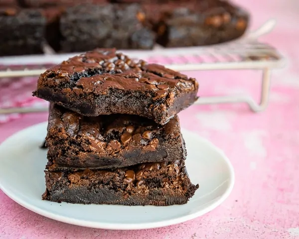 Stack of three chocolate brownies, one with a bite taken out