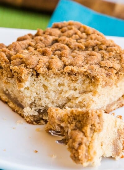 Sour Cream Coffee Cake with a bite taken out on a white plate