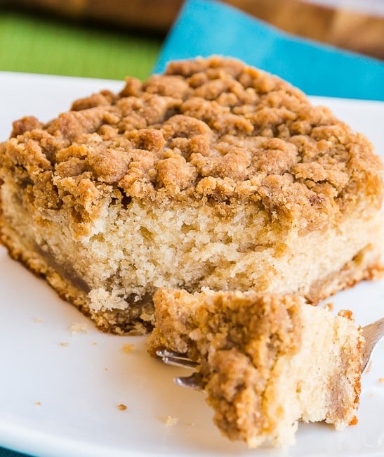 Sour Cream Coffee Cake with a bite taken out on a white plate