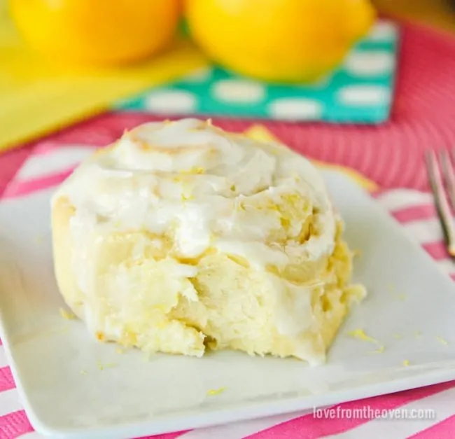 Lemon roll on a white plate with a pink background 