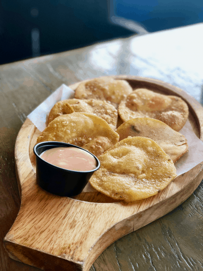 Salt Cod fritters called Bacalaitos on a serving dish with dipping sauce