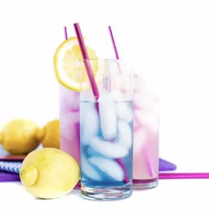Blue cocktail in front of purple cocktails with lemons