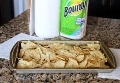 Spread tortilla chips onto a baking sheet