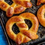 Several soft pretzels on a baking sheet