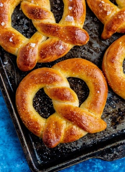 Several soft pretzels on a baking sheet