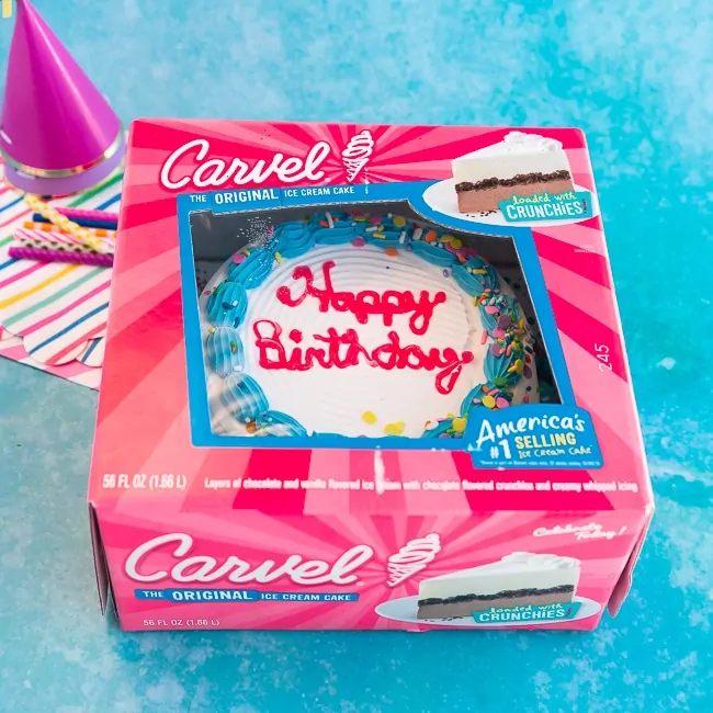 A Carvel ice cream cake in a pink box on a blue background