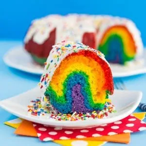 A slice of rainbow bundt cake on a white plate