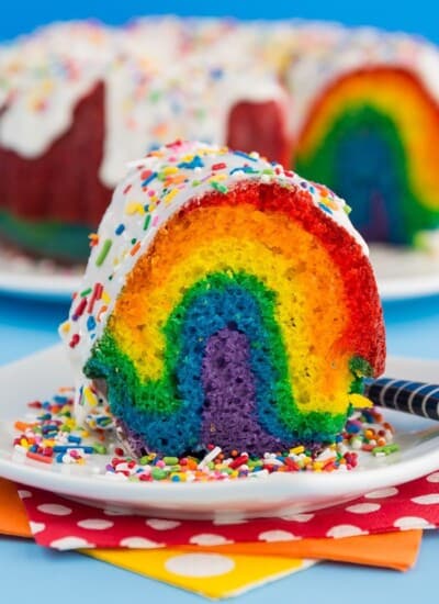 A slice of rainbow bundt cake on a white plate