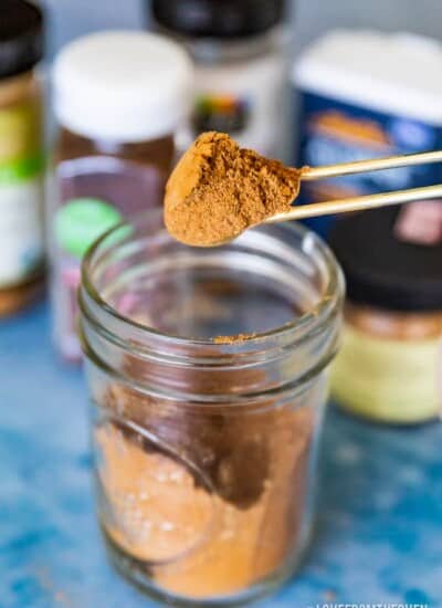 A jar of pumpkin pie spice with a spoonful being taken out