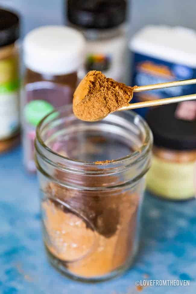 A jar of pumpkin pie spice with a spoonful being taken out