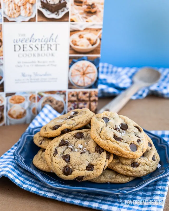 A blue plate of chocolate chip pudding cookies in front of The Weeknight Dessert Cookbook