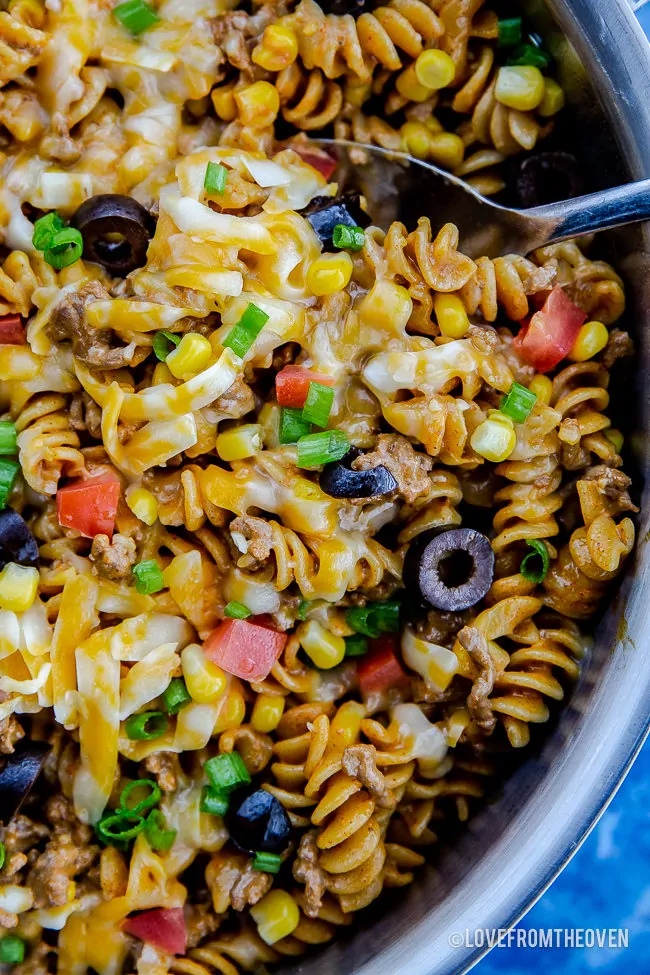 A blue bowl filled with pasta and vegetables