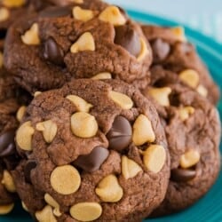 Chocolate peanut butter chip cookies piled on a blue plate