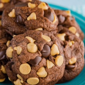 Chocolate peanut butter chip cookies piled on a blue plate