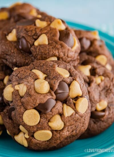 Chocolate peanut butter chip cookies piled on a blue plate