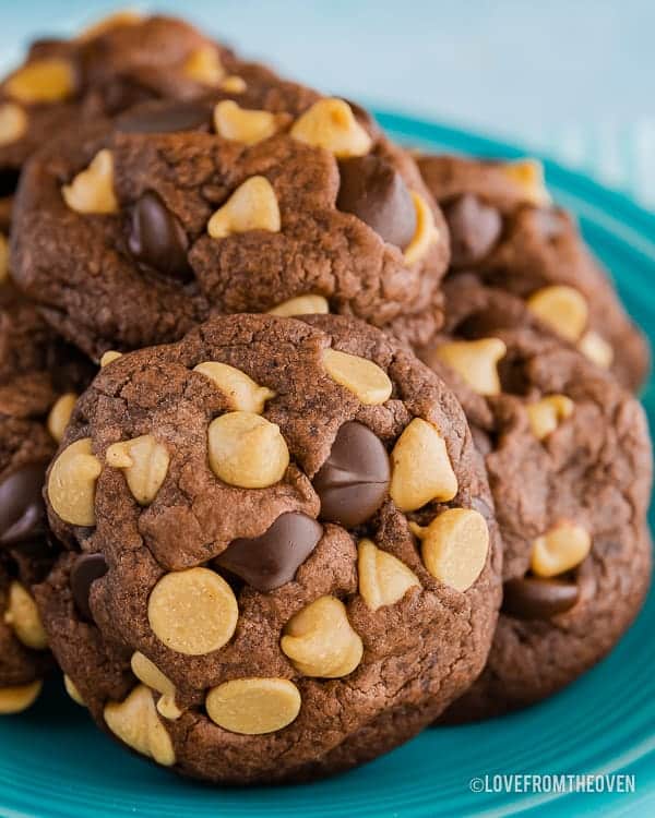 Chocolate peanut butter chip cookies piled on a blue plate