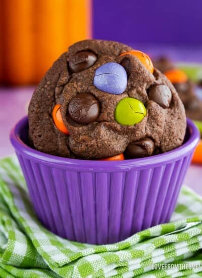 Chocolate Cookie with M&M candies in it, sitting in a purple bowl on top of a green and white napkin