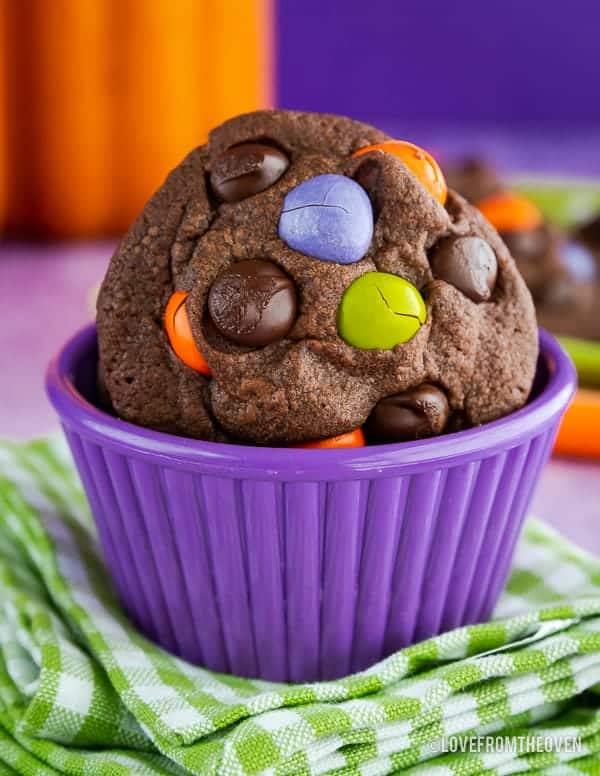 Chocolate Cookie with M&M candies in it, sitting in a purple bowl on top of a green and white napkin