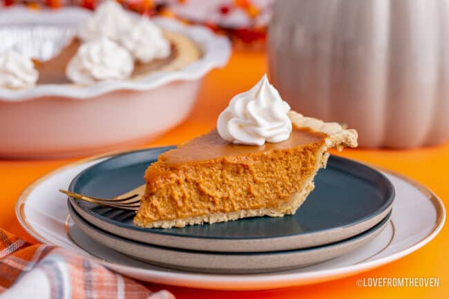 a slice of pumpkin pie on a dark blue plate