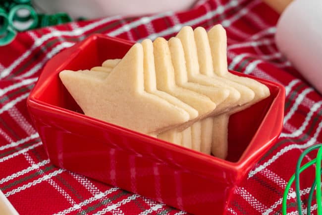 Several star shaped sugar cookies in a red container