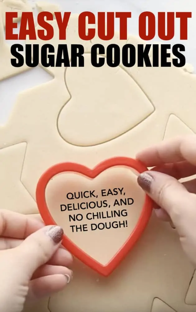 Sugar cookies being cut out with a heart shaped cookie cutter