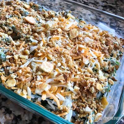 Raw ingredients for green bean casserole in a glass baking pan