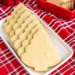 Christmas tree shaped cookies on a white plate with a red napkin