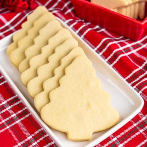 Christmas tree shaped cookies on a white plate with a red napkin