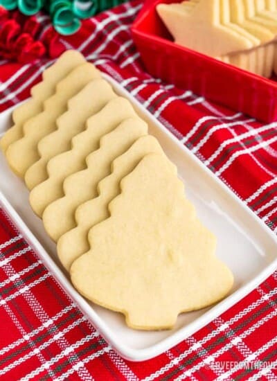 Christmas tree shaped cookies on a white plate with a red napkin