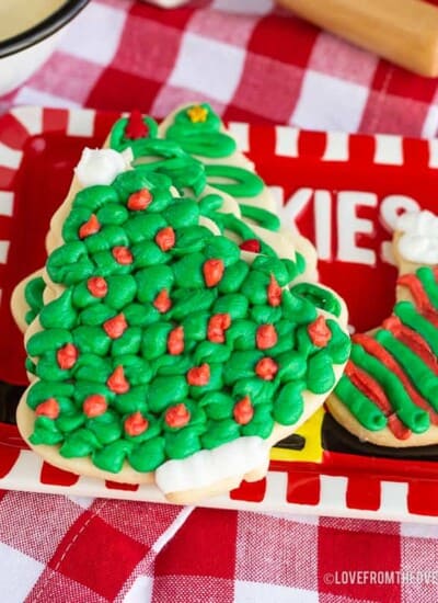 Several frosted sugar cookies on a red plate