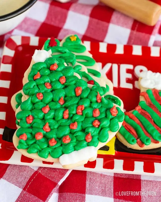 Several frosted sugar cookies on a red plate