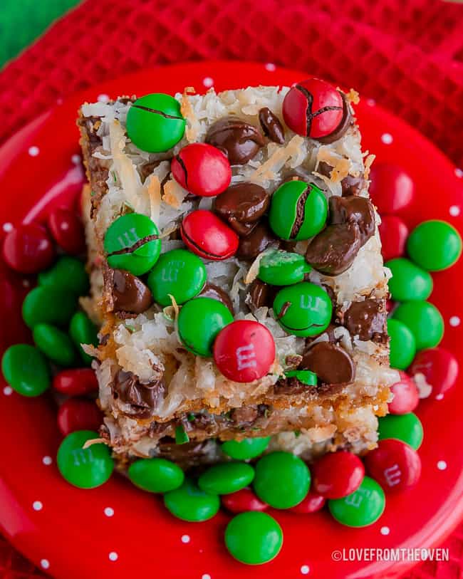 Close up of 7 layer bars covered in M&Ms on a red plate